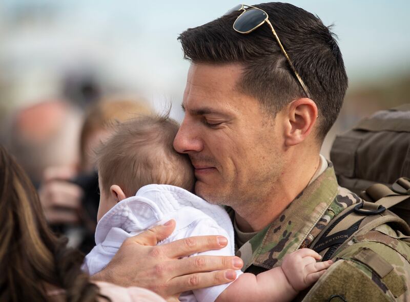 Maj. Doug Boytim hugs his child while greeting his family after returning home from a seven-month deployment to the Middle East with the 729th Air Control Squadron at Hill Air Force Base on Monday, April 29, 2019. The 128 airmen that deployed contributed