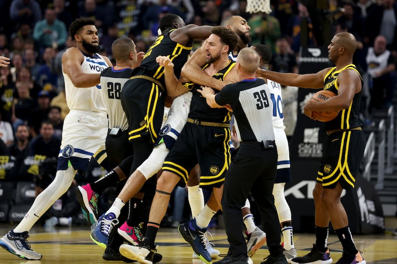 Golden State Warriors guard Klay Thompson, front, and Draymond Green, left, get into an altercation with Minnesota Timberwolves center Rudy Gobert