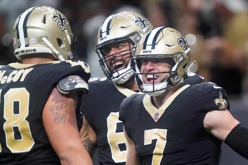 New Orleans Saints’ Taysom Hill, right, celebrates his 60 yard rushing touchdown with Erik McCoy, left, and J.P. Holtz during an NFL football game against the Seattle Seahawks in New Orleans, Sunday, Oct. 9, 2022.