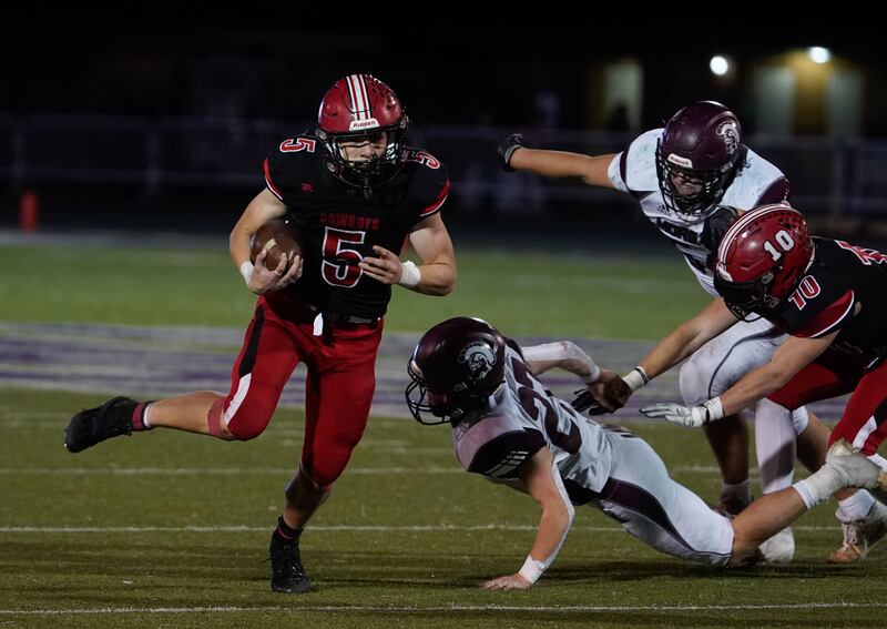 Grantsville’s Gabe Mouritsen, left, runs past Morgan defenders as they compete in the 2021 3A football championship game.