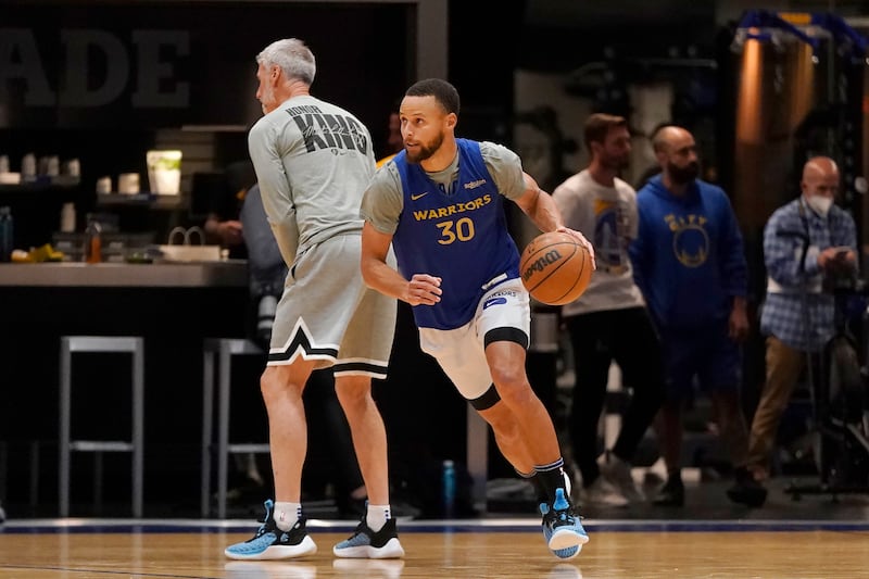 Golden State guard Stephen Curry, right, dribbles past assistant coach Bruce Fraser during practice in San Francisco,