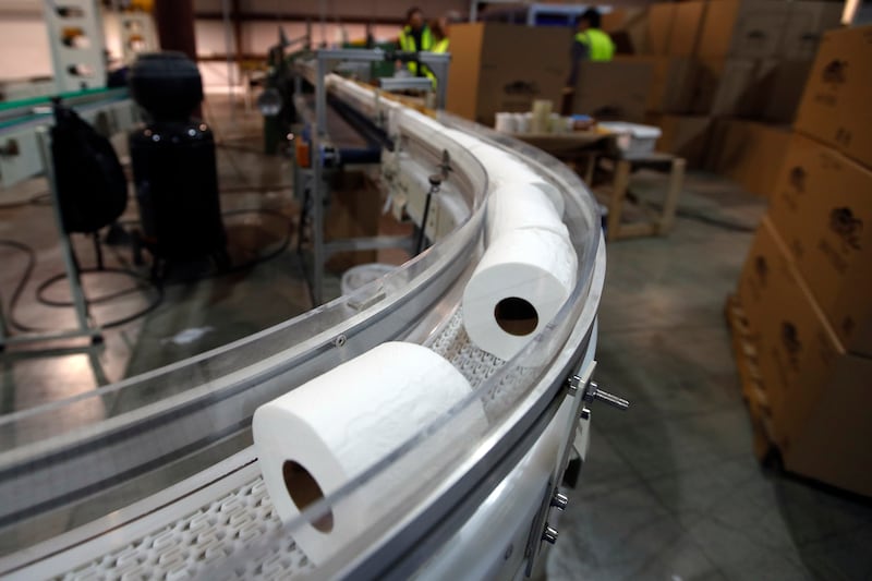 Toilet paper moves out from a cutting machine at the TissuePlus factory in Bangor, Maine.