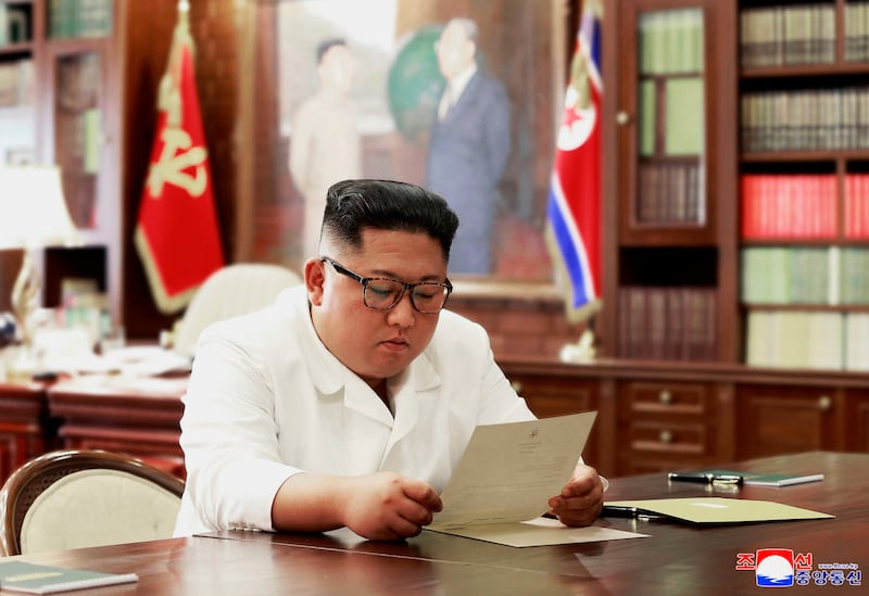 In this undated photo provided on Sunday, June 23, 2019, by the North Korean government, North Korean leader Kim Jong Un reads a letter from U.S. President Donald Trump. Independent journalists were not given access to cover the event depicted in this ima