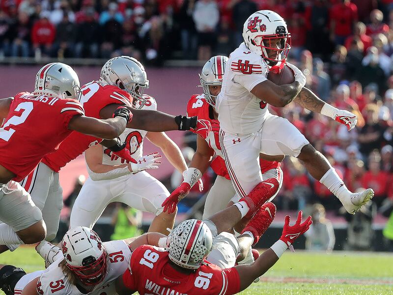 Utah running back T.J. Pledger jumps over Ohio State’s Ryan Watts in the 108th Rose Bowl game in Pasadena, California.