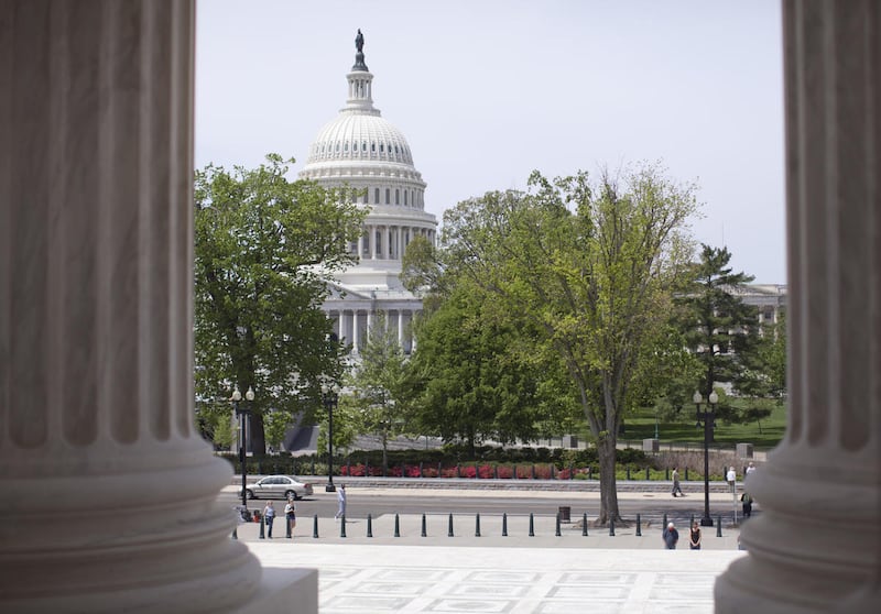 In this May 5, 2014, file photo, the Capitol building is seen through the columns on the steps of the Supreme Court in Washington.