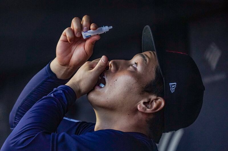 Boston Red Sox’s Masataka Yoshida puts in eye drops in the dugout