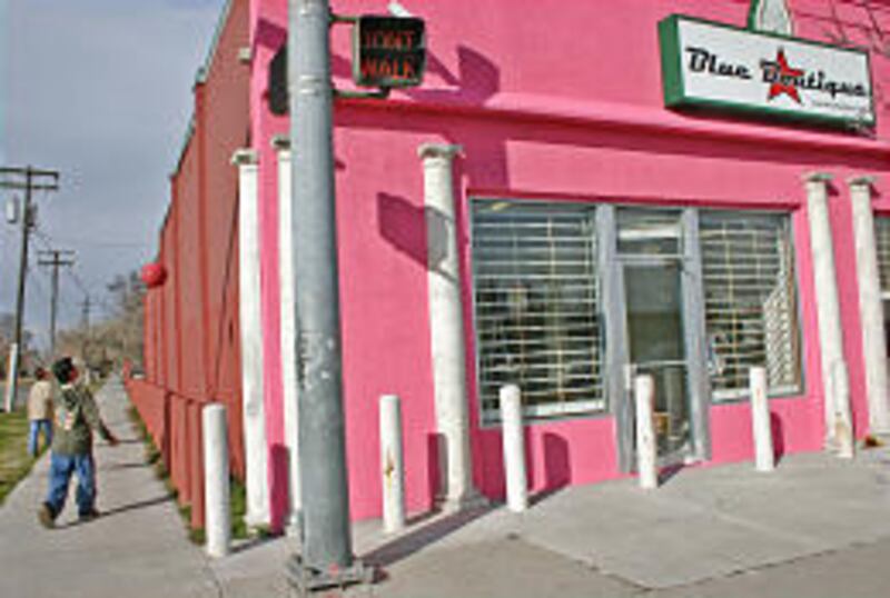Two neighborhood boys bounce balls against the building where the Blue Boutique plans to open.