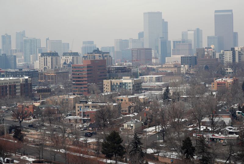 As traffic rolls along Speer Boulevard in the foreground, the skyline is shrouded as pollution fills the air in Denver.