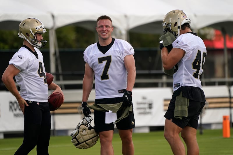 New Orleans Saints tight end/quarterback Taysom Hill (7) pauses between drills with punter Blake Gillikin (4) and long snapper Zach Wood (49).