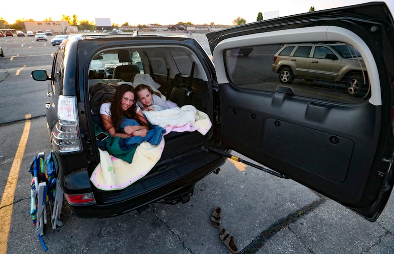 Ellie and Willow Vogel get comfortable in the back of their car as they attend a movie at the Redwood Drive-In Theatre in West Valley City on Friday, May 1, 2020. Moviegoers had to park with two empty spaces between each vehicle as the drive-in theater reopened after being closed because of the COVID-19 pandemic.
