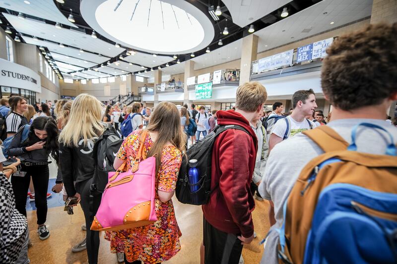 Emily Arthur weaves her way through the crowd to get to class at Corner Canyon High School in Draper on Thursday, April 26, 2018.