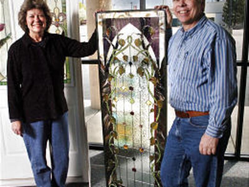 Connie and Jim Johnson, owners of Designer Glassworks, display a door panel that they made.