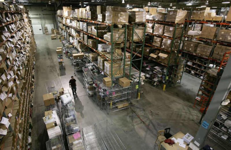 A worker walks between the rows and rows of merchandise in stock at Overstock.com's warehouse and distribution center Friday, March 31, 2006, in Salt Lake City.