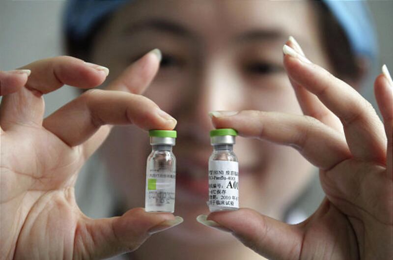 In a photo released by China’s Xinhua news agency, a medical staffer displays A/H1N1 influenza vaccines Wednesday in Beijing.