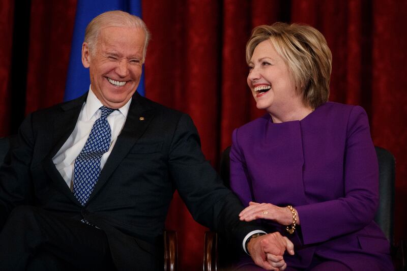 Then Vice President Joe Biden, left, laughs with former Secretary of State Hillary Clinton on Capitol Hill in 2016 in Washington.