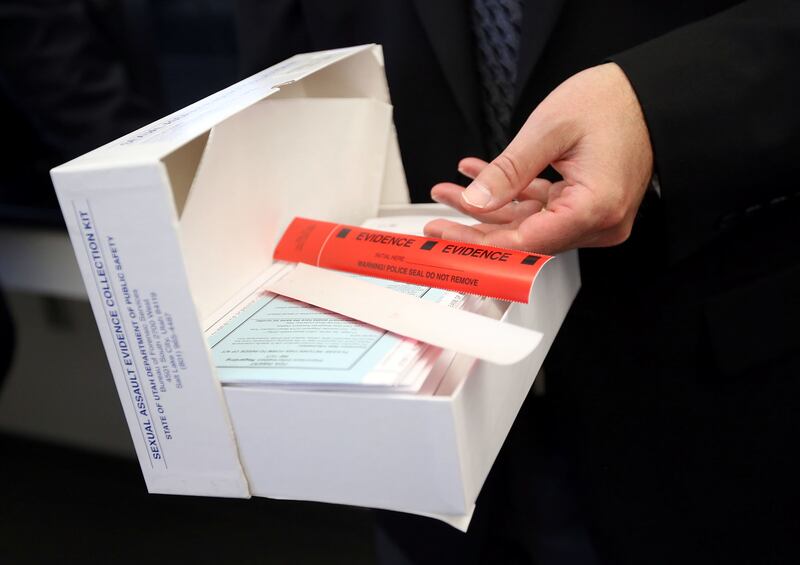 FILE - State Crime Lab director Jay Henry opens up a sexual assault evidence collection kit during a press conference to announce the new Sexual Assault Kit Initiative (SAKI) group with the Commission on Criminal and Juvenile Justice and the Utah Departme
