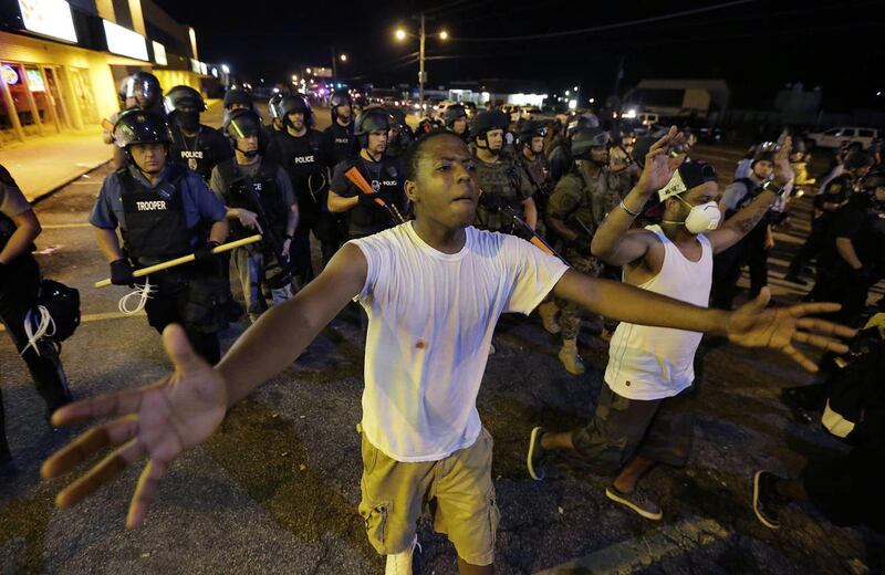 People are moved by a line of police as authorities disperse a protest in Ferguson, Mo. early Wednesday, Aug. 20, 2014. On Saturday, Aug. 9, 2014, a white police officer fatally shot Michael Brown, an unarmed black teenager, in the St. Louis suburb.