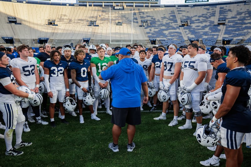 BYU players huddle around head coach Kalani Sitake after a scrimmage at LaVell Edwards Stadium on Aug. 17, 2024.