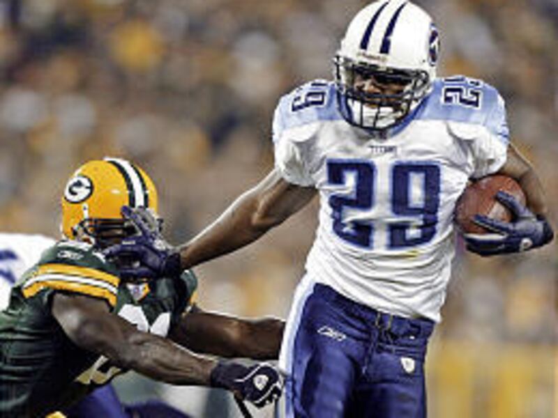 Tennessee running back Chris Brown (29) pushes away Green Bay safety Bhawoh Jue during a 29-yard touchdown run Monday.