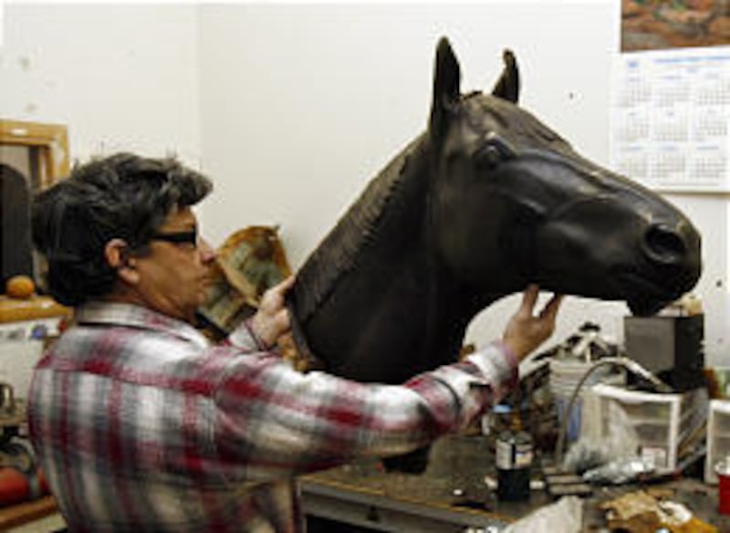 Welder Mario Montemeyer holds the wax cast of the head of Seabiscuit.