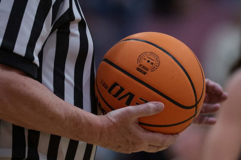 A referee holds the ball during a high school basketball game on Tuesday, Dec. 12, 2023.