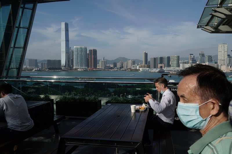 A man eats in a restaurant at waterfront in Hong Kong, Thursday, Oct. 15, 2020. Hong Kong and Singapore say they have agreed to a bilateral air travel bubble, re-establishing travel links as coronavirus infections in both cities decline.