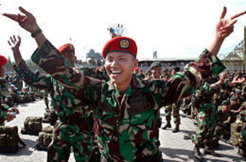 Indonesian Army soldiers sing and dance in celebration Thursday prior to their withdrawal from Krueng Geukuh port in Lhokseumawe, Aceh province, Indonesia.