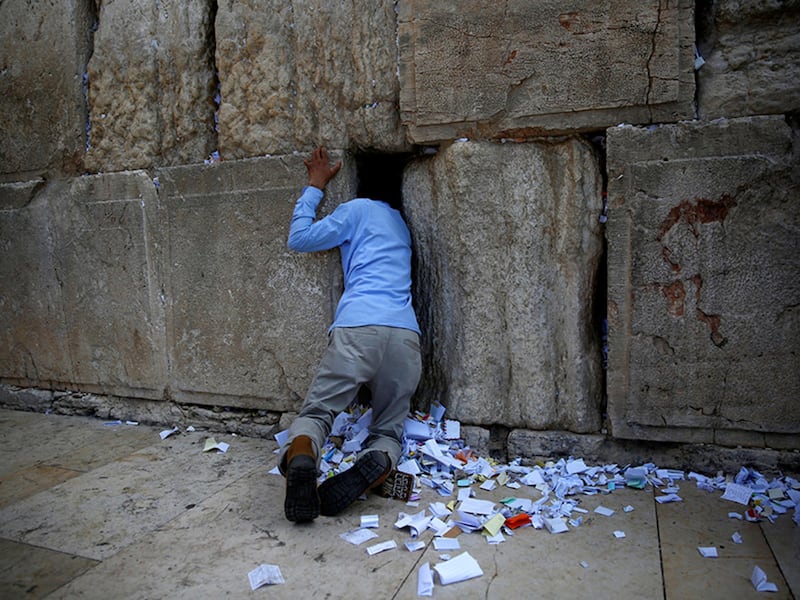 A man clears notes placed in the cracks of the Western Wall, Judaism's holiest prayer site, to clear space for new notes ahead of the Jewish New Year, in Jerusalem's Old City on September 27, 2016.