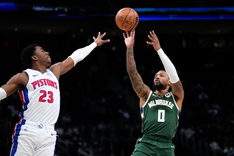 Milwaukee Bucks guard Damian Lillard (wearing green) shoots on Detroit Pistons guard Jaden Ivey in the first half of an NBA basketball game in Detroit, Monday, Jan. 22, 2024.