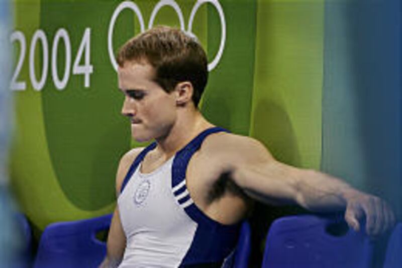 Paul Hamm of the United States sits after failing to medal on the pommel horse.