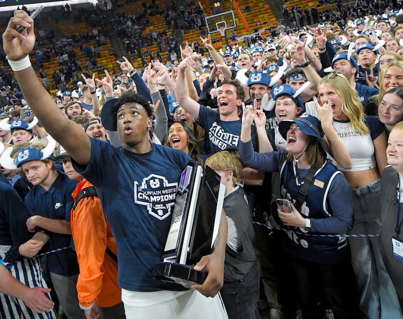 Utah State forward Great Osobor celebrates with fans after the team's win over New Mexico Saturday, March 9, 2024, in Logan, Utah.
