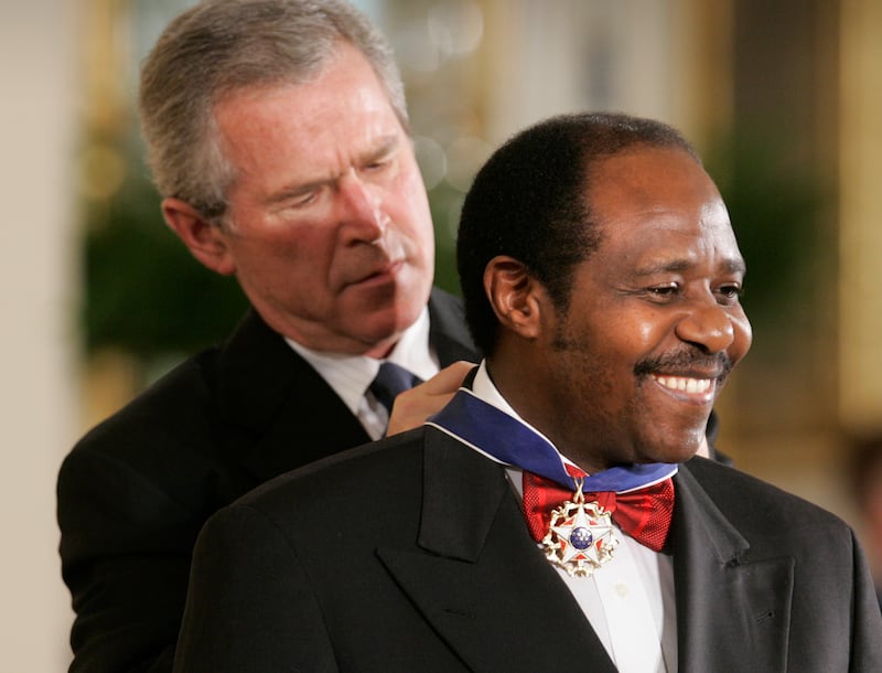 In this Wednesday, Nov. 9, 2005 file photo, President George W. Bush awards Paul Rusesabagina, who sheltered people at a hotel he managed during the 1994 Rwandan genocide, the Presidential Medal of Freedom Award in the East Room of the White House, in Washington.