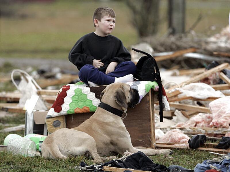 Michael Keisling, 5, and his dog, Mattie, sit among the rubble of their house in Hartsville, Tenn., Wednesday.