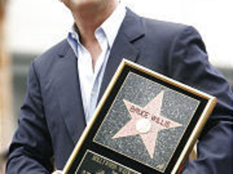 Bruce Willis holds his plaque.
