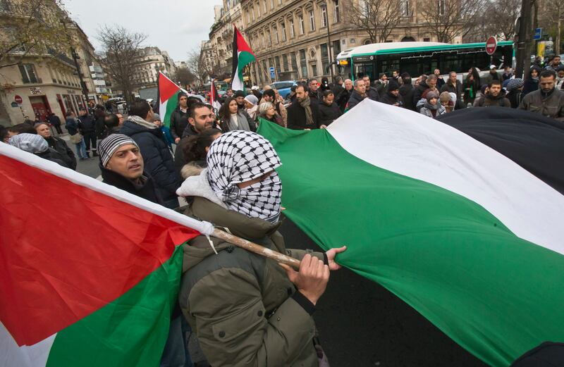 Demonstrators hold a Palestinian flag as they stage a protest against U.S. President Donald Trump's decision to recognize Jerusalem as the capital of Israel in Paris, France, Sunday, Dec. 17, 2017. An estimated 400 protestors gathered Sunday in the rally