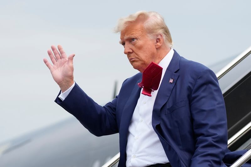 Former President Donald Trump waves as he steps off his plane at Ronald Reagan Washington National Airport, on Aug. 3, 2023.