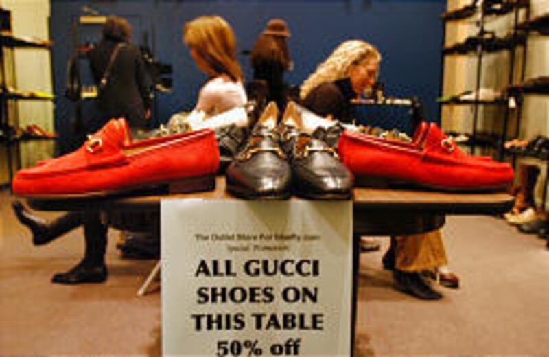 Lorie Venice, left, and Diane Lederman try on shoes at a sample sale of designer clothes at Bluefly.com in New York City.