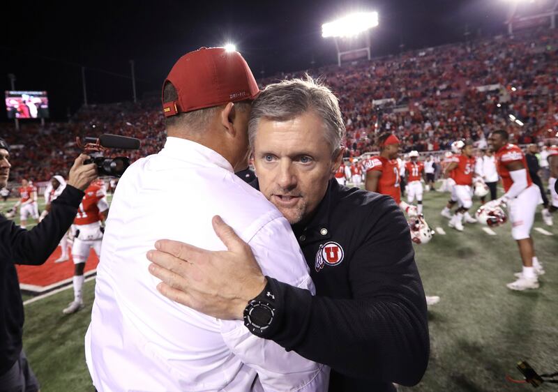 Utah head coach Kyle Whittingham, right, shakes hands with USC head coach Clay Helton following their game, Oct. 20, 2018.