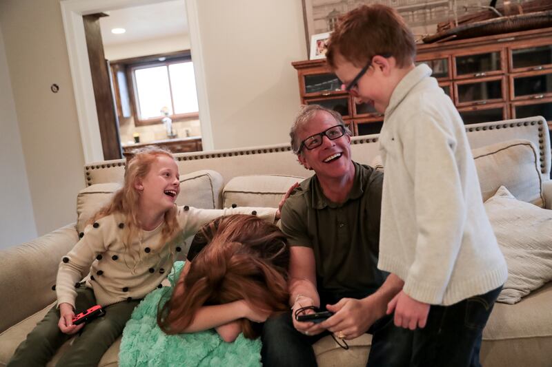 Casey Scott claims victory while playing video games with his kids, Frankie, 11, Preslee, 14, and Boden, 7, left to right, at his home in Farmington on Friday, March 22, 2019.