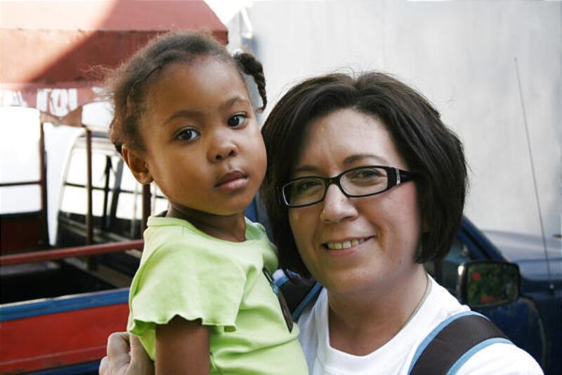 Candice Aitken holds Nerlande, 4, one of three Haitian children Aitken and her husband, David, are adopting.