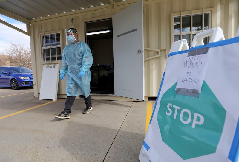 Utah National Guard Spc. Brandon Hernandez approaches a vehicle that has arrived for COVID-19 testing outside of the Utah Department of Health in Salt Lake City on Wednesday, Feb. 10, 2021.