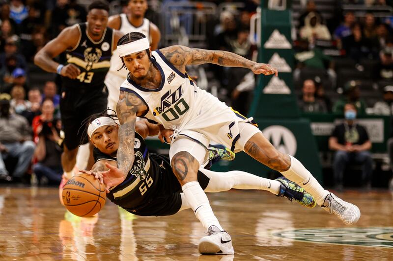 Milwaukee Bucks guard Justin Robinson (55) and Utah Jazz guard Jordan Clarkson (00) reach for the ball.