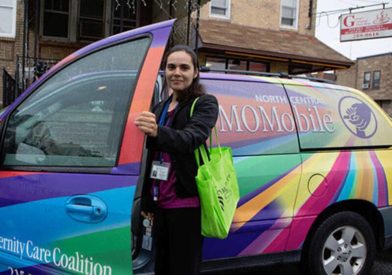A Momobile manager steps out of her car on her way to a visit with a client.