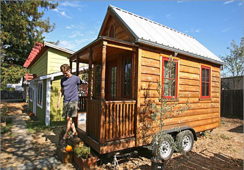 Jay Shafer, co-founder of the Small House Society, poses in 2010 with cottages he built in Graton, Calif.