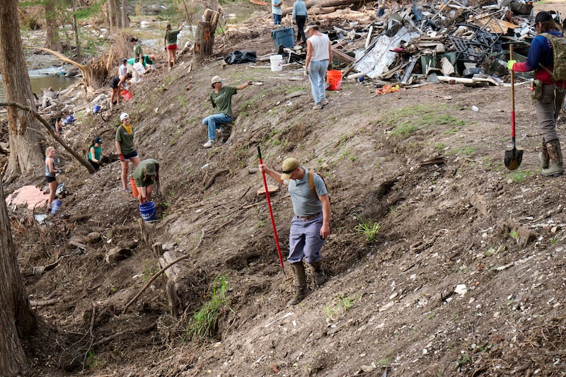 Volunteers from the Boerne congregation of The Church of Jesus Christ of Latter-day Saints and the Cypress Creek Church in Wimberley, Texas, gather items from the Guadalupe River in Hunt, Texas, on July 26, 2025, following the severe flooding in central Texas on July 4, 2025.