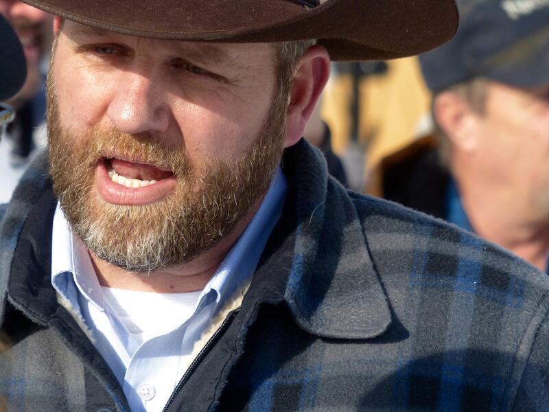 FILE - Ammon Bundy chats with a protester Saturday, Jan. 2, 2016, during a march on behalf of a Harney County ranching family in Burns, Ore. Bundy, the son of Nevada rancher Cliven Bundy, who was involved in a standoff with the government over grazing rig