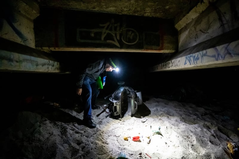 Shawn Spalding, an outreach worker at Volunteers of America - Utah, walks under a bridge along the Jordan River after talking to two homeless individuals for the annual Point-in-Time count in South Salt Lake on Thursday, Jan. 24, 2019.