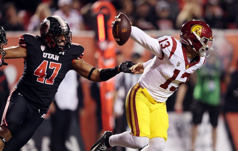 USC quarterback Caleb Williams escapes the grasp of Utah’s Miki Suguturaga in Salt Lake City on Saturday, Oct. 15, 2022.
