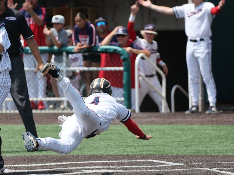 Crimson Cliffs’ Petey Soto (wearing white) dives into home