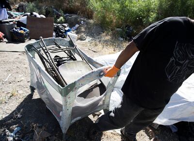 Following reports of illegal camping, excessive litter and human waste, workers with multiple agencies clear out camps located east of Victory Road in the foothills north of Salt Lake City on Thursday, June 14, 2018.